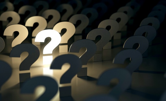 Question marks against a dark background, one is lit up