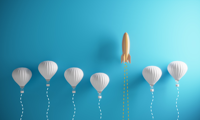 Photo of several ballons floating in space with a single rocket higher above them