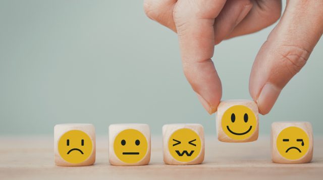 Photo of five small blocks, each with a different face emoji to show different emotions