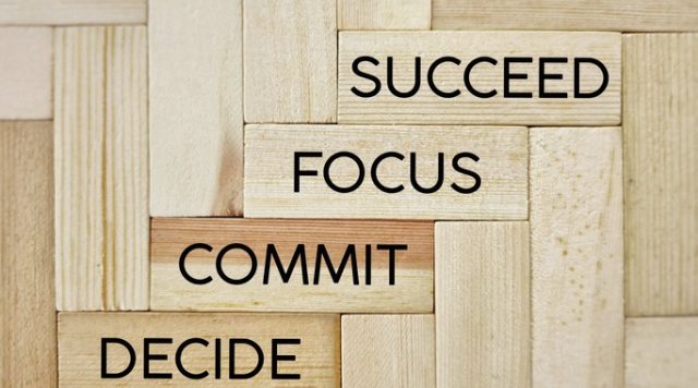 Wooden blocks with the words "decide", "commit", "focus", "succeed"