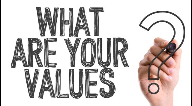 A hand with a marker writing "What are your values?"